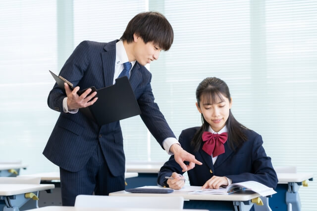 教室で指示を出すスーツの男性