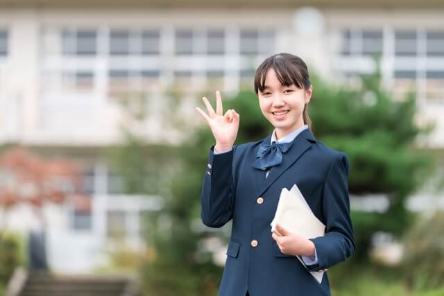 学校前で手を振る制服の学生