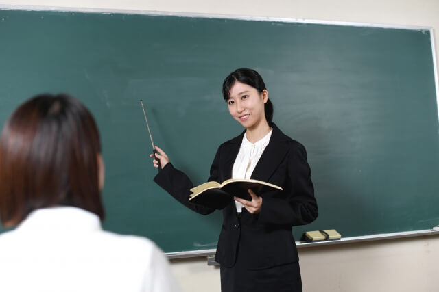 教室で板書を示す女性教師